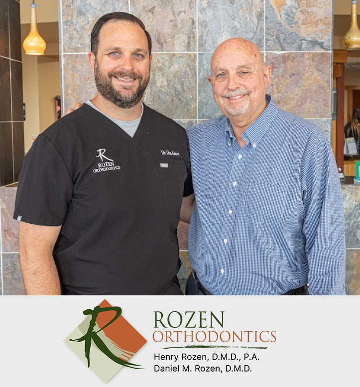 Two men smile at camera in dental office with Rozen Orthodontics logo displayed below.
